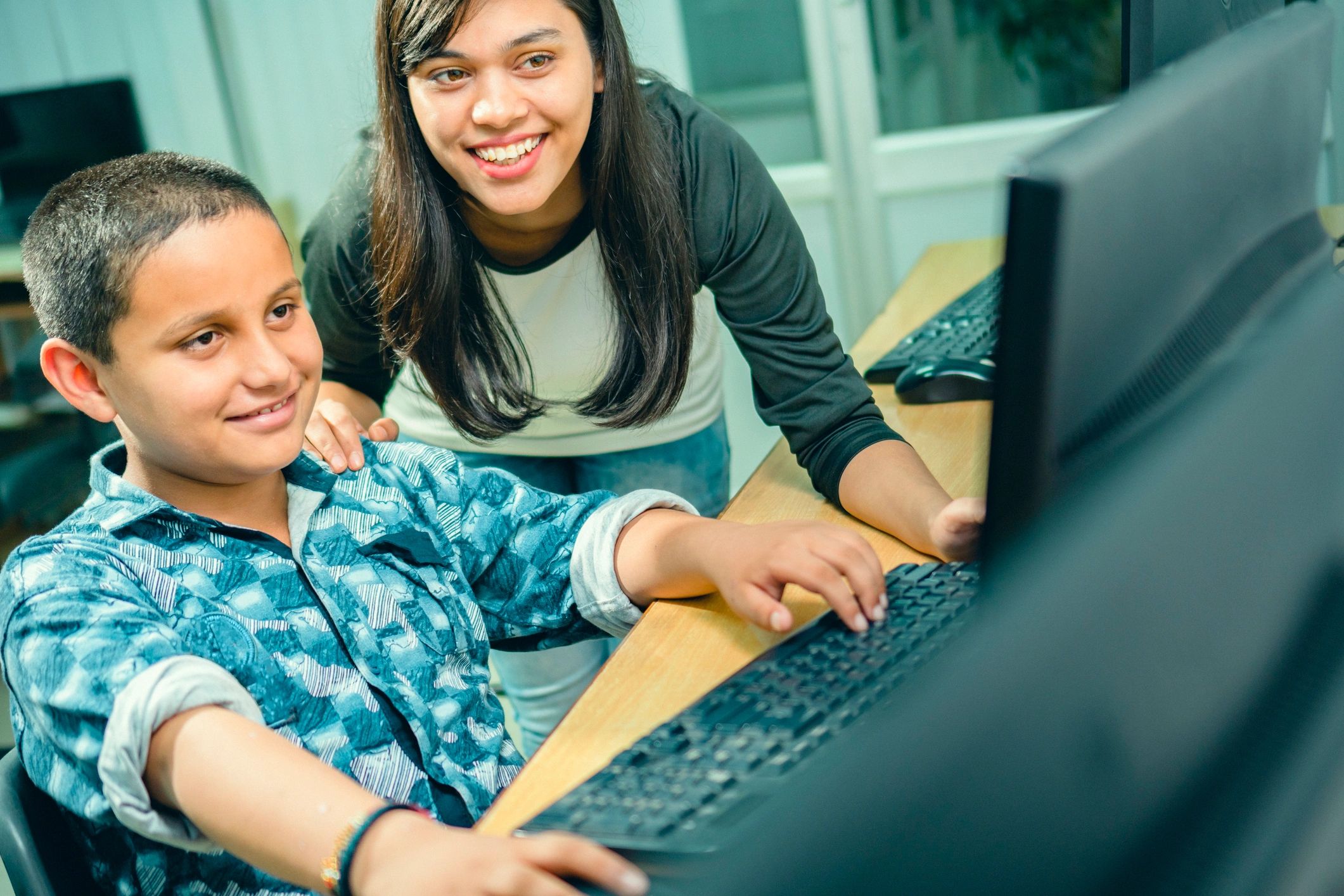 Teacher helping a student during a computer-based lesson
