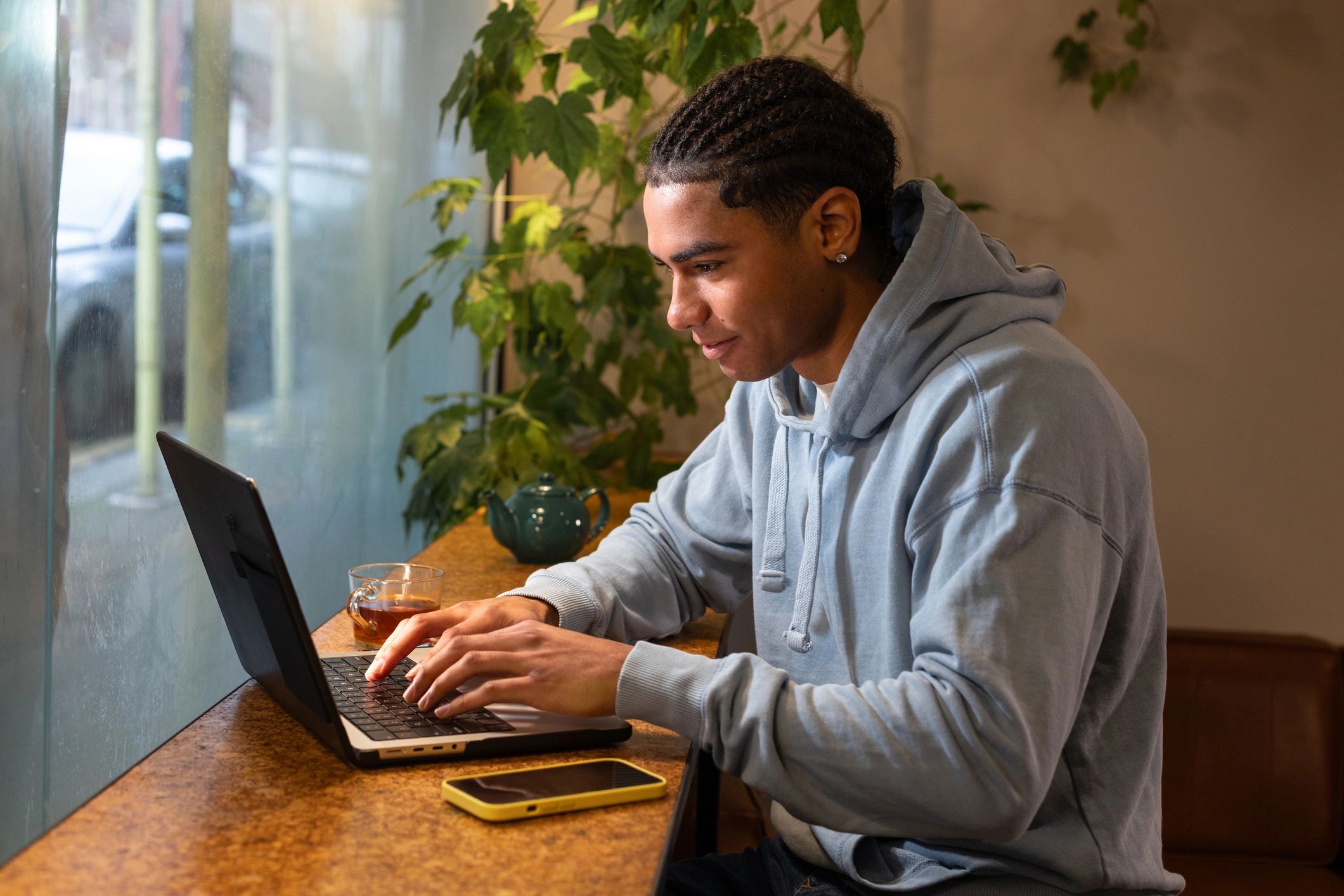 Student smiling while studying on a laptop