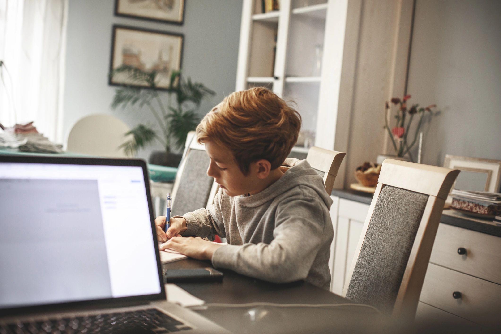 Boy completing homeschooling assignments at a table