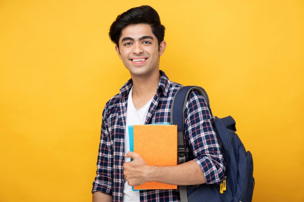 Male teenage student in yellow background stock photo