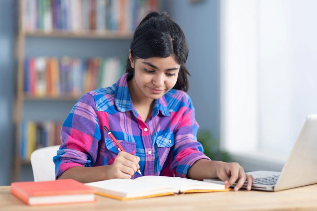 Teenage girl studying at home stock photo