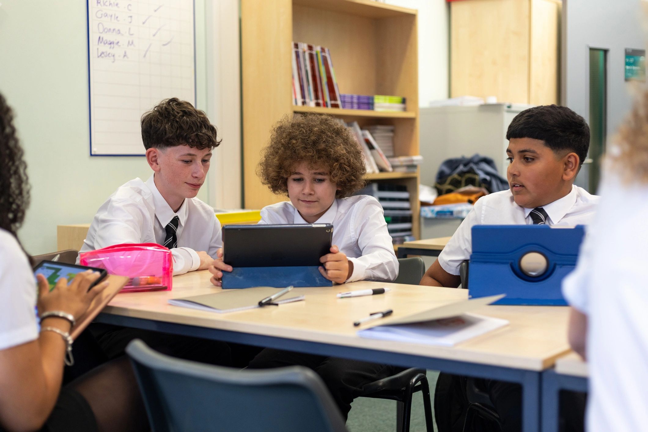 Diverse students learning together with tablets in a modern classroom